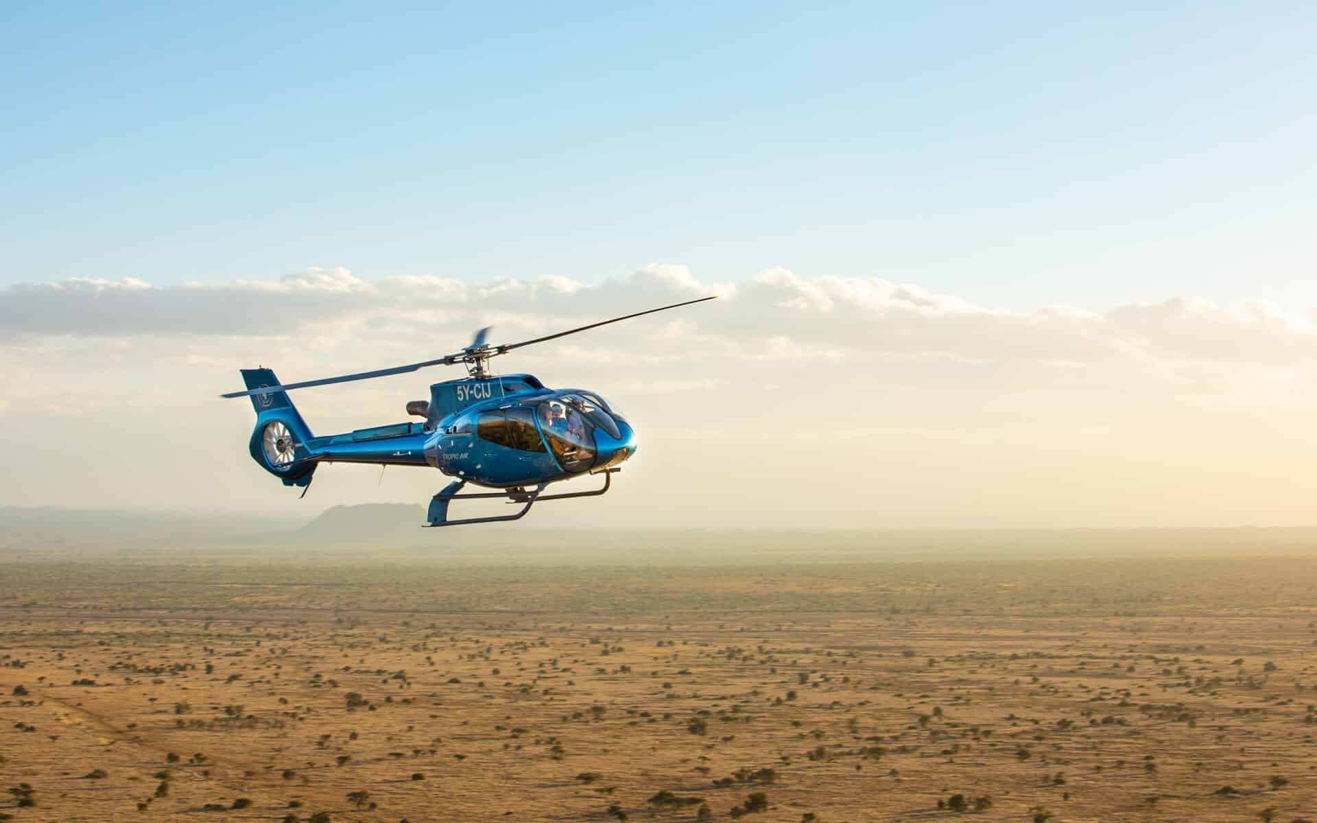 Helicopter flying low over the Kenyan plains on a flying safari
