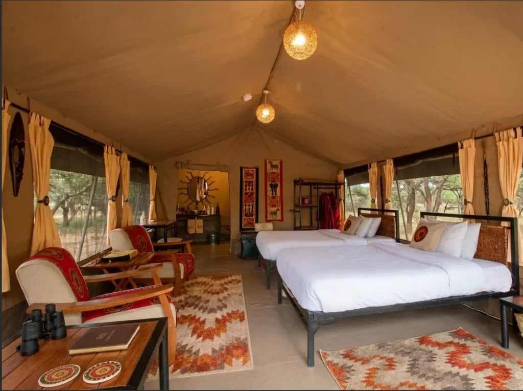 Luxury tented safari suite with twin beds and lanterns