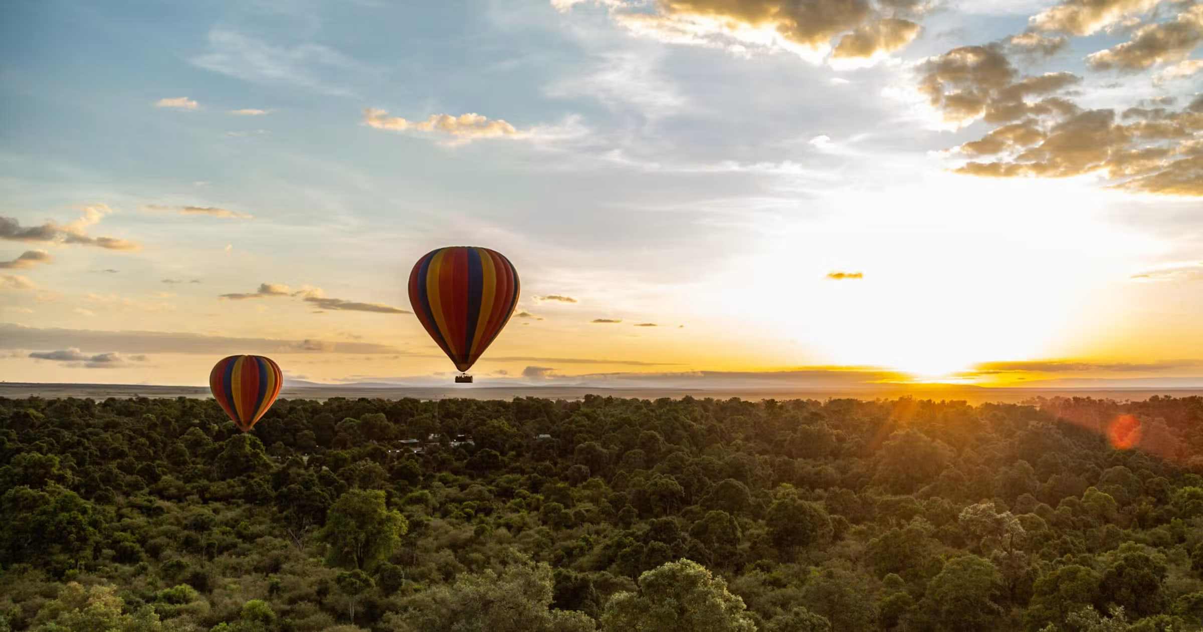 Hot-air balloons drifting over the Maasai Mara at sunrise
